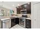 Well-equipped kitchen with stainless steel appliances, quartz countertops, and dark wood cabinets at 25302 Lido Ave, Sorrento, FL 32776