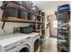 Functional laundry room with ample shelving, modern washer and dryer, and storage solutions at 25302 Lido Ave, Sorrento, FL 32776