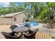 Serene backyard pool area surrounded by lush landscaping, deck, and a cozy outdoor seating space at 25302 Lido Ave, Sorrento, FL 32776