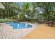 Beautiful backyard pool area with mature trees, a hot tub, and outdoor seating with a fire pit at 25302 Lido Ave, Sorrento, FL 32776
