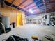 Unfinished basement with exposed wood ceiling, shelving, water heater, and open doorway at 2900 Cr 415, Lake Panasoffkee, FL 33538