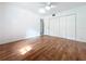 Bedroom featuring wood floors, a ceiling fan, and closet with folding doors at 2900 Cr 415, Lake Panasoffkee, FL 33538