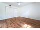 Bedroom with wood flooring, ceiling fan, and spacious closet with folding doors at 2900 Cr 415, Lake Panasoffkee, FL 33538
