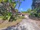 Home with stone facade and attached garage on a sunny day, showcasing the front yard and driveway at 2900 Cr 415, Lake Panasoffkee, FL 33538