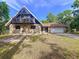 Inviting home with stone accents, a balcony, and an attached two-car garage, set against a blue sky at 2900 Cr 415, Lake Panasoffkee, FL 33538
