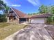 Quaint home featuring stone detailing, a front balcony, an attached garage, and a concrete driveway at 2900 Cr 415, Lake Panasoffkee, FL 33538