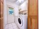 Bright laundry room with washer, dryer, cabinets, and exterior door at 2900 Cr 415, Lake Panasoffkee, FL 33538