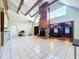 Open living room with high ceilings, wood beams, a stone fireplace, and tiled floors at 2900 Cr 415, Lake Panasoffkee, FL 33538