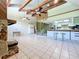 Bright living room with stone fireplace, high ceilings, spiral staircase and open floor plan to the kitchen at 2900 Cr 415, Lake Panasoffkee, FL 33538
