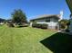 Spacious backyard with lush lawn, manicured hedges, and a peek at the neighboring homes at 2528 Deerbrook Dr, Lakeland, FL 33811