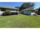 Manicured backyard with lush green lawn, trimmed hedges, and a detached garage at 2528 Deerbrook Dr, Lakeland, FL 33811