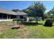 Fenced backyard featuring mature trees, lush greenery, and a detached garage for extra storage at 2528 Deerbrook Dr, Lakeland, FL 33811