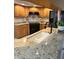 Close-up of a granite countertop featuring wooden cabinetry and tile backsplash in the kitchen at 2528 Deerbrook Dr, Lakeland, FL 33811