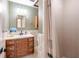 Well-lit bathroom featuring a shower, vertically-striped wallpaper, and wooden vanity at 3646 Palm Rd, Lakeland, FL 33810