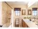 Bathroom vanity with white sink and dark brown cabinet and decorative tile tub surround at 3646 Palm Rd, Lakeland, FL 33810