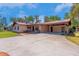The home's exterior features a long driveway, carport, and front porch with railings at 3646 Palm Rd, Lakeland, FL 33810