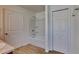 Bathroom features a white tub and shower combination with white doors and wood look flooring at 4601 Glencrest Loop, St Cloud, FL 34772