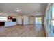 Open-concept living area with laminate flooring, slider, large windows, and views into kitchen at 4601 Glencrest Loop, St Cloud, FL 34772