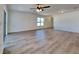 Spacious living room featuring laminate flooring, large windows, and a modern ceiling fan at 4601 Glencrest Loop, St Cloud, FL 34772