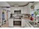 Modern kitchen featuring stainless steel appliances, granite countertops, white cabinets, and ample natural light at 528 S Seminole Ave, Fort Meade, FL 33841