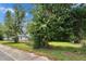 A side yard showcasing a large tree with dense foliage, with glimpses of a house behind a chain-link fence at 528 S Seminole Ave, Fort Meade, FL 33841