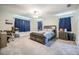Spacious bedroom with a ceiling fan, carpeted floors, blue curtains, and a comfortable king-sized bed at 1416 Leighton Ave, Lakeland, FL 33803