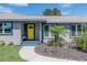 Close-up of a home showcasing a vibrant yellow front door and manicured landscaping at 1416 Leighton Ave, Lakeland, FL 33803