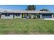 Charming gray home featuring a bright yellow front door and a well-maintained green lawn at 1416 Leighton Ave, Lakeland, FL 33803