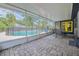 Enclosed patio featuring brick pavers with view of the fenced backyard pool and table with chairs at 1416 Leighton Ave, Lakeland, FL 33803