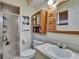 Standard bathroom featuring a glass enclosed shower and wood cabinets above the toilet and sink at 1716 Bayou Cir, Lakeland, FL 33803