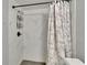 Close up of a marble tiled shower featuring an adjustable shower head and patterned shower curtain at 1716 Bayou Cir, Lakeland, FL 33803