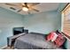 Bedroom with blue walls, ceiling fan, wood-look flooring, and a television on a stand at 1716 Bayou Cir, Lakeland, FL 33803