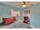 Bedroom with blue walls, window with blinds, ceiling fan, and closet with items inside at 1716 Bayou Cir, Lakeland, FL 33803
