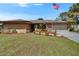 Traditional-style home with manicured landscaping and an American flag out front on a sunny day at 1716 Bayou Cir, Lakeland, FL 33803