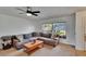 Living room with a gray sectional sofa, coffee table, window with blinds, and a ceiling fan at 1716 Bayou Cir, Lakeland, FL 33803