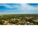 Aerial view of a residential neighborhood with lush trees under a clear blue sky at 2418 Se 23Rd St, Ocala, FL 34471
