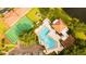 Top-down view of community pool, tennis court, and clubhouse amid lush greenery at 2418 Se 23Rd St, Ocala, FL 34471