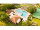 Birds-eye view of community pool, clubhouse, and tennis court surrounded by greenery at 2418 Se 23Rd St, Ocala, FL 34471