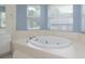 Bright bathroom features a soaking tub with jets and tile surround at 2418 Se 23Rd St, Ocala, FL 34471