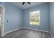 Empty bedroom featuring wood floors, a window, and light-blue walls at 2418 Se 23Rd St, Ocala, FL 34471