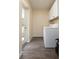 Convenient laundry room with white cabinets and appliances, next to an outside door at 2418 Se 23Rd St, Ocala, FL 34471