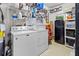 Efficient laundry room with washer, dryer, shelving, and a compact refrigerator for added convenience at 4846 Colonnades Club Blvd, Lakeland, FL 33811