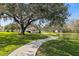 Scenic community walking path leading past lush greenery and a tranquil lake with gazebo at 4846 Colonnades Club Blvd, Lakeland, FL 33811