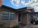 Home exterior featuring a brick facade, a covered entrance, and a well-lit walkway under a cloudy blue sky at 115 Marjorie Ave, Auburndale, FL 33823