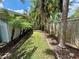 Lush backyard with tropical palm trees and a wood fence line offer privacy at 1618 Pineberry St, Lakeland, FL 33803