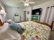 Bedroom featuring a colorful floral quilt, ceiling fan, view to en suite, and a light-filled airy feel at 1618 Pineberry St, Lakeland, FL 33803
