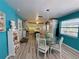Bright dining area with a glass-top table, white chairs, and blue walls, adjacent to the kitchen at 1618 Pineberry St, Lakeland, FL 33803