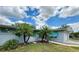 Quaint single-story home with a brick facade, complemented by well-maintained landscaping and mature palm trees at 1618 Pineberry St, Lakeland, FL 33803