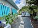 Backyard shed and plumeria bushes sit on gravel bed with paver stones for access at 1618 Pineberry St, Lakeland, FL 33803