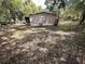 Backyard of the home with privacy fence, mature trees, and lush green grass at 2434 Trenton E Rd, Lakeland, FL 33815